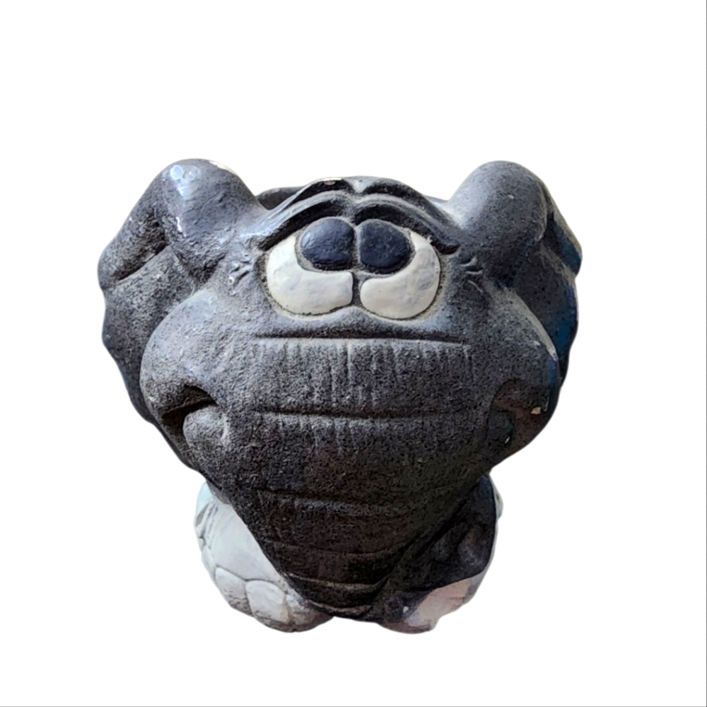 The elephant candlestick is gray and still has the candle with its white legs. I